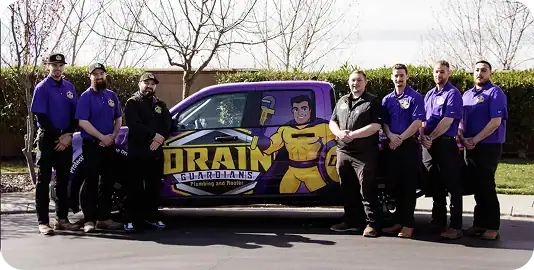Six men stand in a row beside a purple truck with "Drain Guardians" and a superhero graphic on the side.